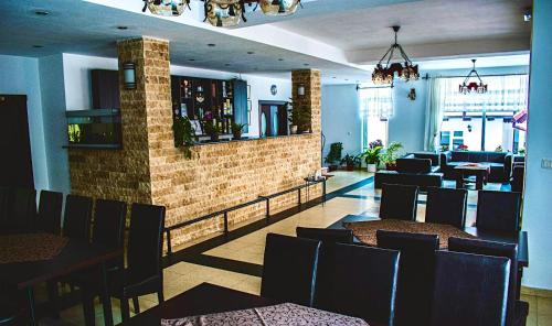 un ristorante con tavoli e sedie e un bar di Pensiunea Orzan a Moieciu de Sus