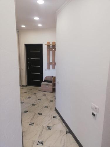 einen Flur mit einem Zimmer mit Tür und Fliesenboden in der Unterkunft VIP apart 326 in Tbilisi City