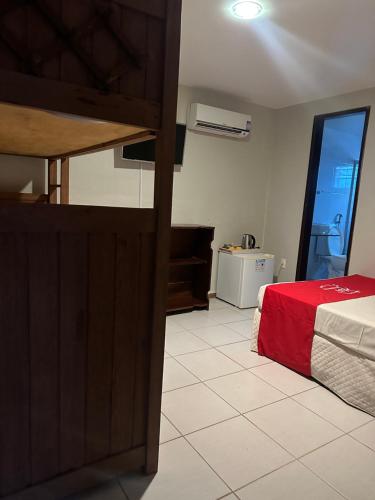 بوسادا فلور دي ماراكا في بورتو دي غالينهاس: غرفة نوم بسرير وبطانية حمراء