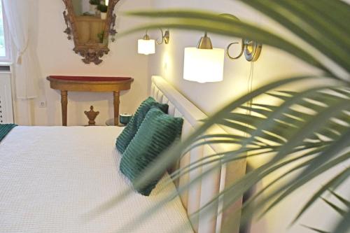 Un dormitorio con una cama blanca y una planta en Green Hill Apartment, en Budapest