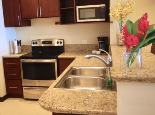 a kitchen with a sink and a stove at Playa Flamingo - 2 BR condo with great ocean views - FLAMINGO TOWERS 25 in Playa Flamingo