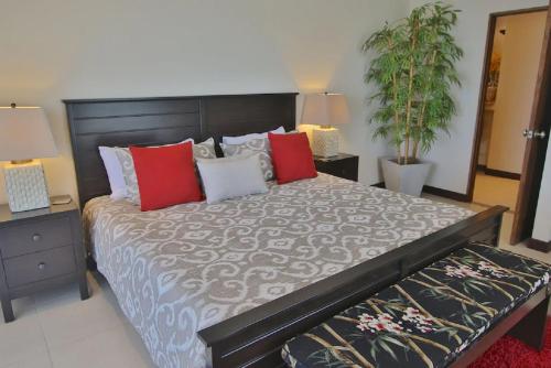 a bedroom with a large bed with red and white pillows at Playa Flamingo - 2 BR condo with great ocean views - FLAMINGO TOWERS 25 in Playa Flamingo