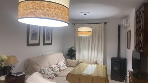 sala de estar con sofá y 2 luces colgantes en Casa Paloseto, en Higuera de la Sierra