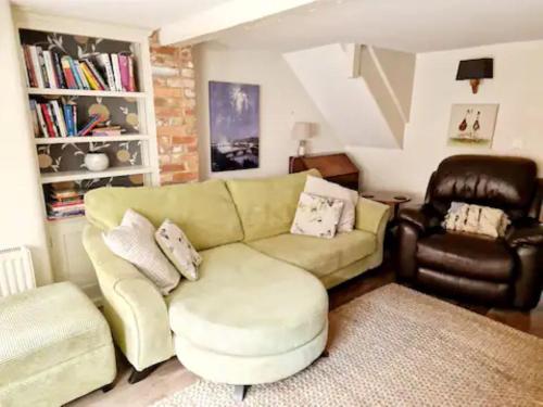 a living room with a couch and a chair at Jackdaw Cottage-Beautiful Cottage, Town Centre in Wimborne Minster