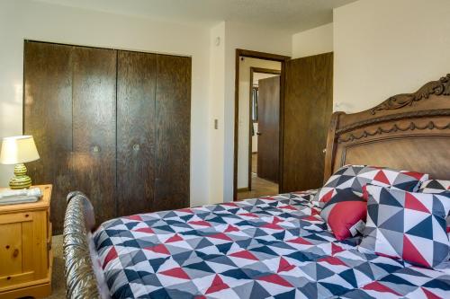 a bedroom with a bed with a checkered blanket at 7 Mi to Munsinger Gardens Sartell Home with Deck in Sartell