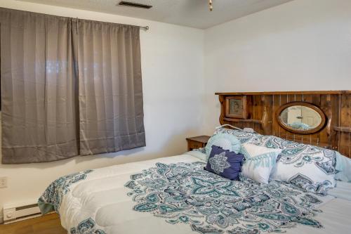 Charming Sartell Home with Deck and Yard! في Sartell: غرفة نوم مع سرير مع اللوح الأمامي الخشبي ومرآة