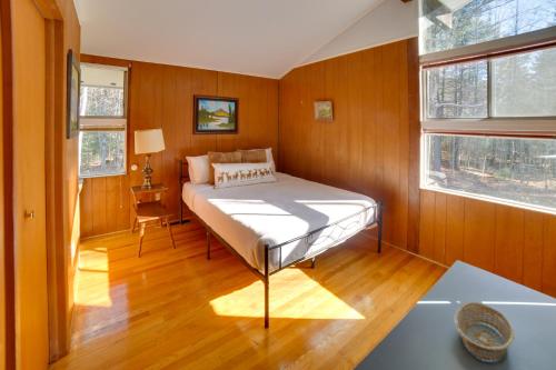 1 dormitorio con 1 cama en una habitación con paredes de madera en Londonderry Vacation Home with Deck and Gas Grill!, en Londonderry