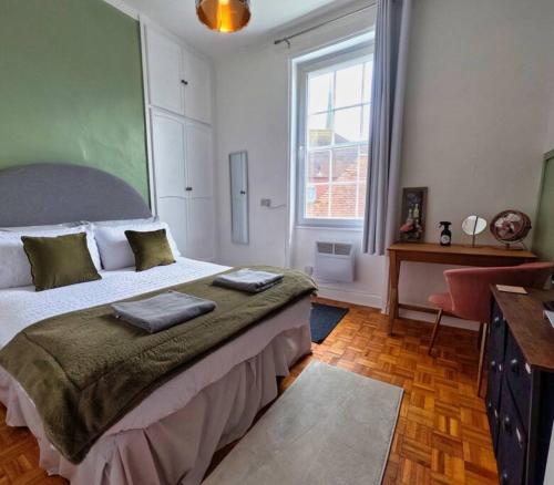 a bedroom with a bed and a desk and a window at Flat in the Heart of Worcester in Worcester