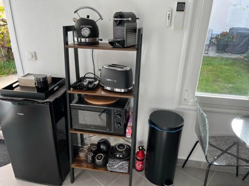 uma cozinha com uma prateleira, um micro-ondas e uma torradeira em Studio proche Paris et aéroport d'Orly em Orly