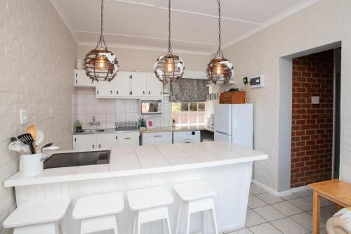 a kitchen with white cabinets and white appliances at Shepherd's Rest in Mossel Bay