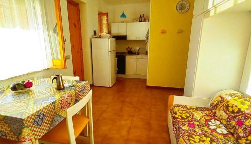 a kitchen with a table and a kitchen with a refrigerator at Margherita sul mare - 250 m from the beach in San Giorgio