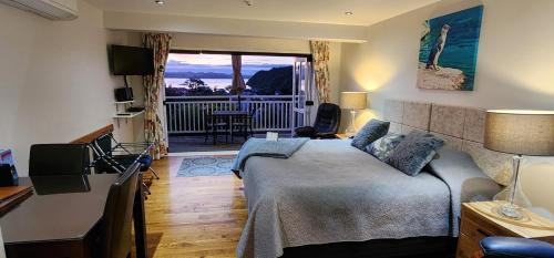 a bedroom with a bed and a desk and a balcony at Bellrock Lodge in Russell