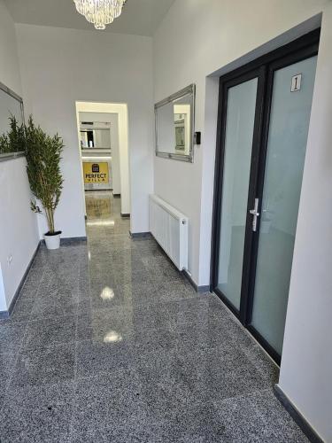 a hallway with a glass door in a building at PERFECT VILLA Ploiesti in Ploieşti