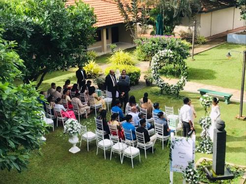 a group of people sitting in chairs at a wedding ceremony at Laya Beach in Wadduwa