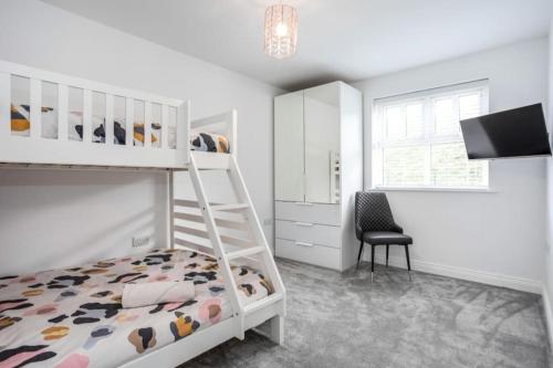 a bedroom with a bunk bed and a chair at Modern Apartment Portrush in Portrush