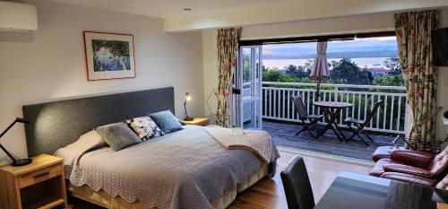 a bedroom with a bed and a balcony at Bellrock Lodge in Russell