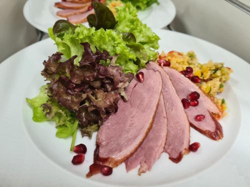 a plate of food with meat and a salad at Hotel Krone in Königsbrunn
