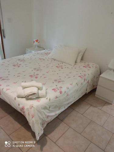 een bed met een wit dekbed met bloemen erop bij Casa peo in Benevento