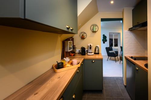 une cuisine avec des placards verts et un comptoir en bois dans l'établissement COZY F2 40m2 Appartement Climatisé Château, à Montbéliard