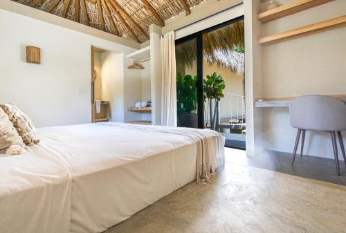 a bedroom with a bed and a large window at Raíz Hotel Boutique in Puerto Escondido