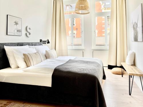 - une chambre avec un lit doté de draps et d'oreillers blancs dans l'établissement MAKERS + ROOMS APARTMENTS, à Detmold