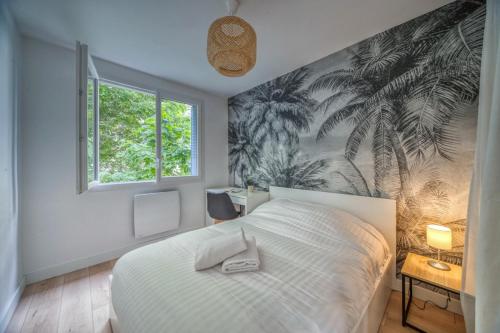 グルノーブルにあるChemin des sportsのベッドルーム1室(ヤシの木の壁画のあるベッド1台付)