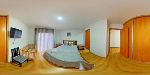 ヴィエイラ・ド・ミーニョにあるCasa das Caméliasのベッドルーム1室(ベッド1台、椅子付)