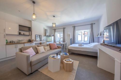 a living room with a couch and a bed at Le rendezvous cocooning des grenoblois in Grenoble