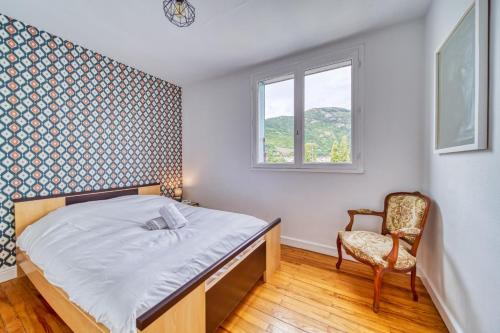 ein Schlafzimmer mit einem Bett, einem Stuhl und einem Fenster in der Unterkunft Le Ferjus in Grenoble