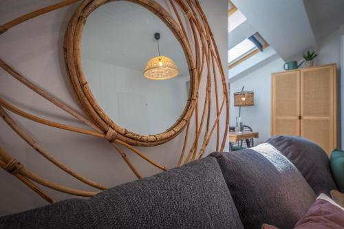 a large mirror hanging on a wall next to a couch at Le rendezvous au jardin des grenoblois in Grenoble