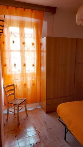 a bedroom with a bed and a chair and a window at Casa vacanze nel Parco Nazionale della Majella in Montenerodomo