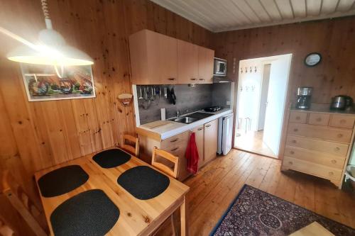 a kitchen with a table and a sink in a room at Idyllic vacation home near lake: nature&fireplace in Stöde