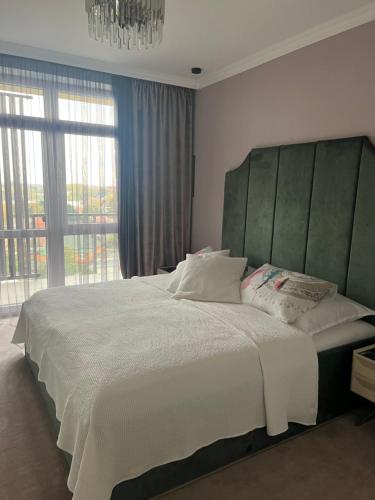 1 dormitorio con 1 cama grande y ventana grande en White Lotus en Nyíregyháza