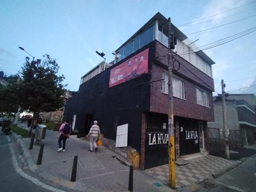 a building on a street with people walking past it at Aparta estudio bonito, independiente bien ubicado in Bogotá