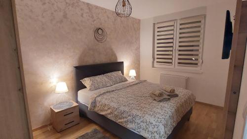 een slaapkamer met een bed met een paar schoenen erop bij Apartment Ela in Subotica