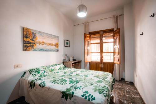een slaapkamer met een bed en een schilderij aan de muur bij QH Gran Via 01 in Granada