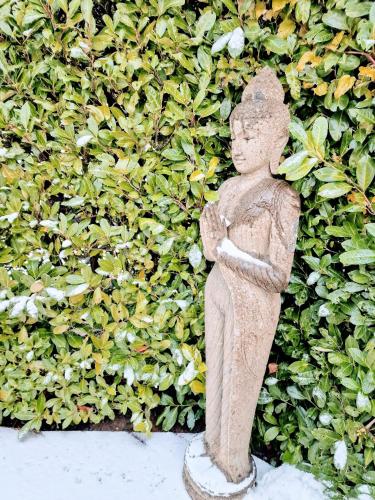a statue of an angel standing in front of a hedge at Bella Flocon appartements min 2 Nights Special weekly and monthly prices in Savièse