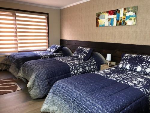 a bedroom with two beds and a window at mirabosque new aparments 2 in Osorno