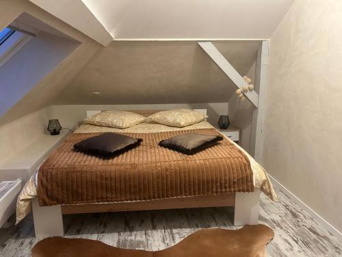 a bedroom with a bed with two pillows on it at SUITE WILLA CHEZ WILLI in Niederschaeffolsheim
