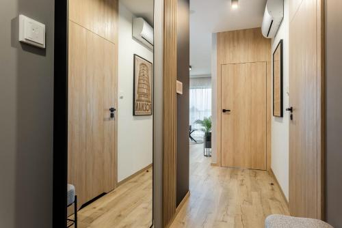 korytarz z drewnianymi drzwiami i drewnianą podłogą w obiekcie Very Berry - Zwierzyniecka 15 - City Center Apartment, Parking, self check in 24h! w Poznaniu