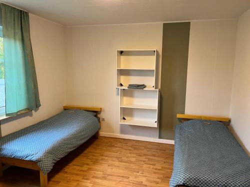 a room with two beds and a book shelf at Zimmer 1 in Bullendorf
