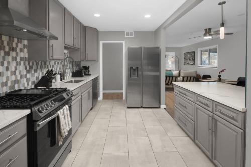 a kitchen with stainless steel appliances and a living room at Spacious home near Anschutz/DIA in Aurora