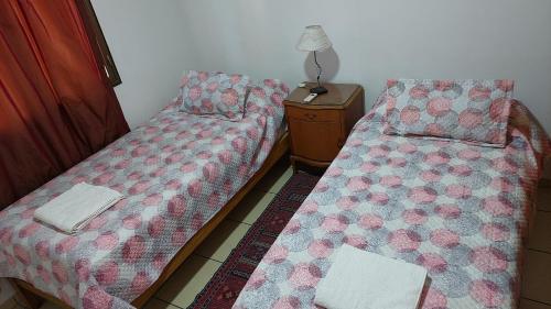 dos camas sentadas una al lado de la otra en una habitación en Departamento a 100mts de los Portones del Parque en Mendoza