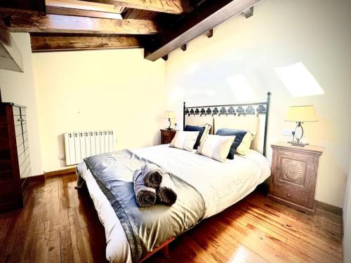 una camera da letto con un grande letto con cuscini sopra di Ático duplex a pie de pistas de esquí a La Molina