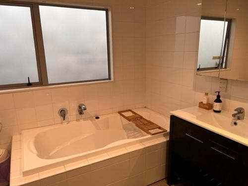 a bathroom with a large tub and a sink at Villa Sebastian - Large Modern Home in Wellington