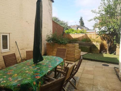 a table and chairs with a table and a umbrella at 6 En-Suite Bedrooms; Garden; Driveway;Pet Friendly in Bournemouth