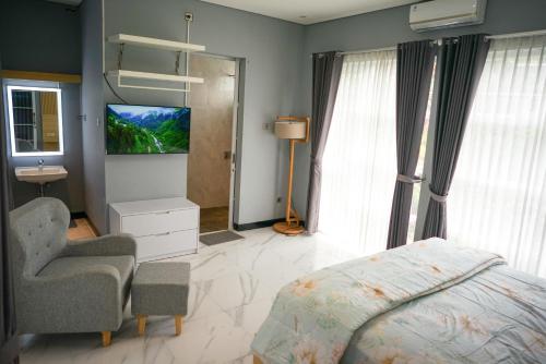 una camera con letto, TV e sedia di Villa Languket I a Bedoyo