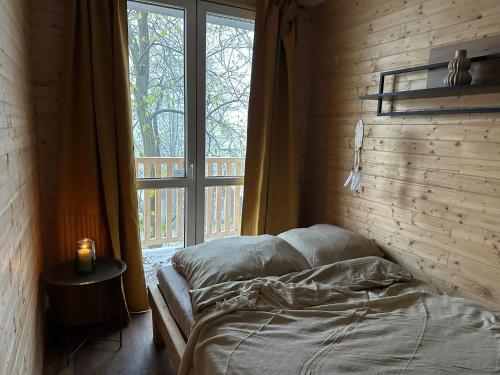 a bedroom with a bed and a large window at Tiny house v Moravském Berouně in Moravský Beroun