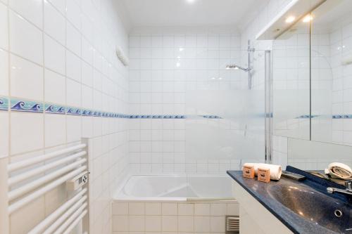 une salle de bain avec un lavabo et une baignoire dans l'établissement Dolce Vita YourHostHelper, à Cannes