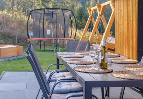 a wooden table with wine glasses and a gazebo at Chalet Pølarka in Demanovska Dolina